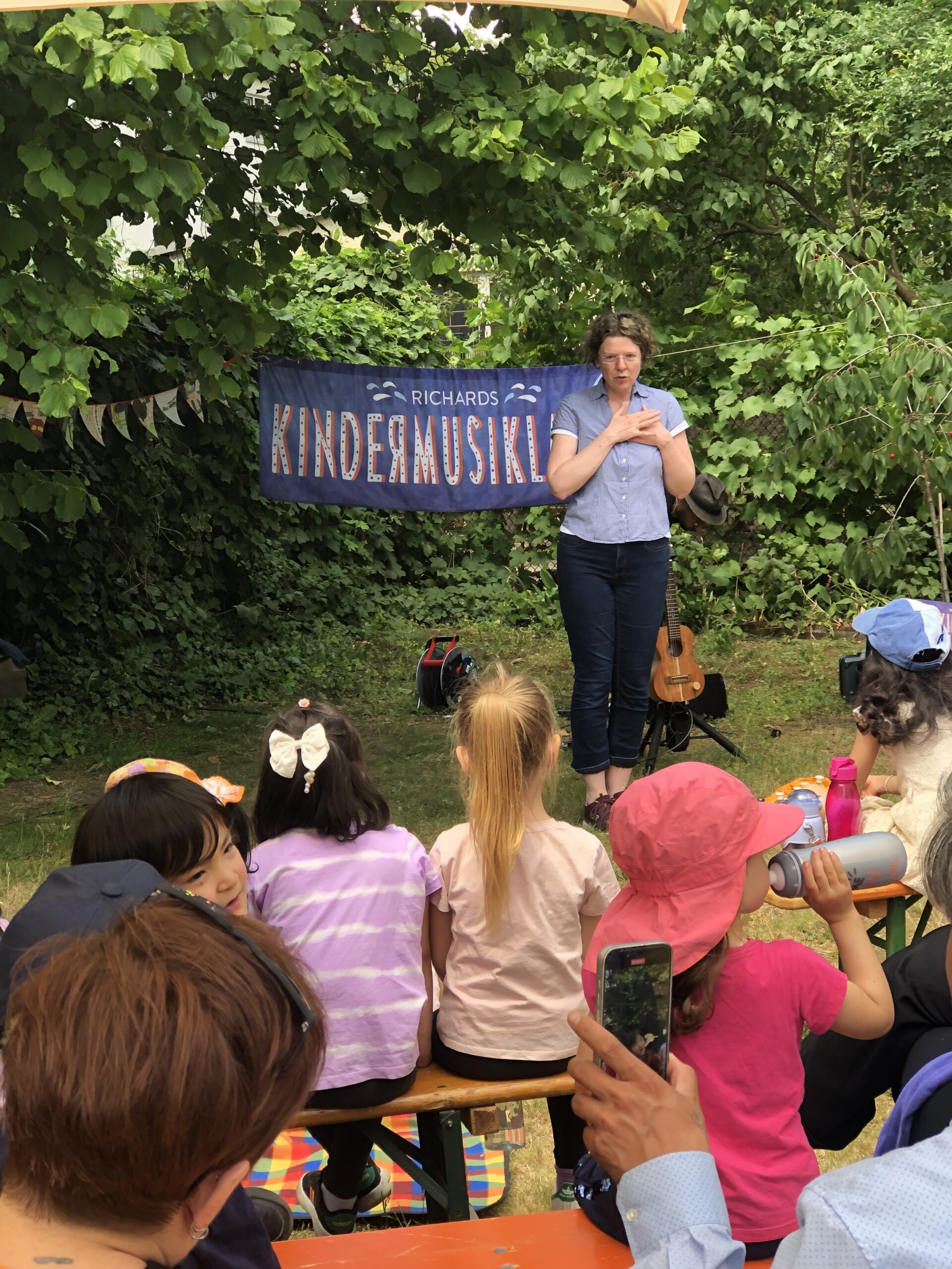 Korinna Stephan steht vor einem Publikum vor Kindern und eröffnet das Musikfestival.